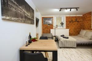 a living room with a table and a brick wall at LOFTY CHOPINA in Bydgoszcz