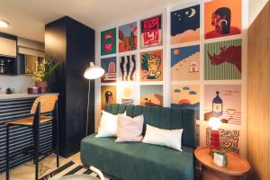 Diseño en el corazón de Punta Carretas في مونتيفيديو: غرفة معيشة مع أريكة خضراء ومطبخ