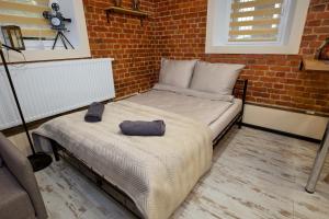 a bedroom with a bed and a brick wall at LOFTY CHOPINA in Bydgoszcz