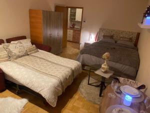 マリボルにあるApartment La Vieのベッドとソファとテーブルのある寝室