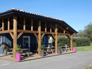 a large wooden pavilion with tables and potted plants at Le heron cendre in Orist