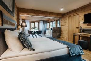 a large bed in a room with wooden walls at New Apartamenty Jan in Zakopane