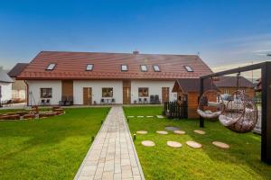 a house with a green yard with two swings at Osada REST Tylicz in Tylicz