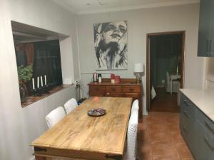 a dining room with a wooden table and a kitchen at Urban Oasis Cape Town in Cape Town