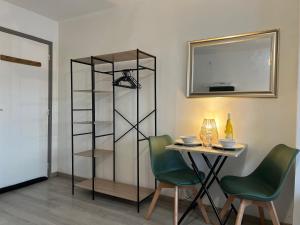 Zimmer mit einem Tisch, 2 Stühlen und einem Spiegel in der Unterkunft Le Bonheur Nature, proche gare in Yzeure