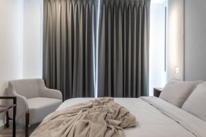 a bedroom with a bed and a chair and a window at Nuevo Departamento en Zibatá Querétaro, 4 Personas in La Cañada