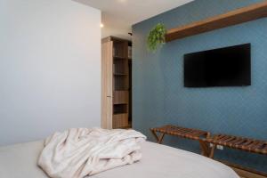 a bedroom with a bed and a tv on a wall at Nuevo Departamento en Zibatá Querétaro, 4 Personas in La Cañada