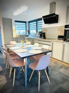kuchnia ze stołem i krzesłami w kuchni w obiekcie Coast House 25 -TRZĘSACZ SUNNY SIDE BALTIC w Trzęsaczu