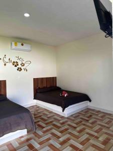 Un dormitorio con 2 camas y un ventilador en una habitación en Posada chachalacas, en Chachalacas