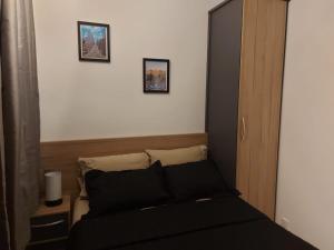 a bedroom with a black bed with two pictures on the wall at Flat / Studio Allianz Parque in São Paulo