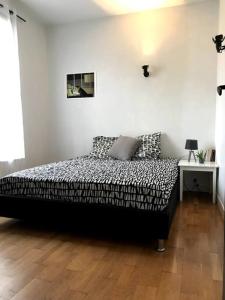 a bedroom with a bed and a wooden floor at Pavillon avec cour privée in Bagnolet