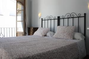 a bedroom with a large bed with white sheets and pillows at Apartamentos La Ciudad in Ronda +15 photos