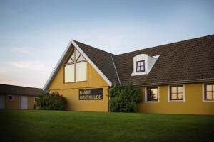 un edificio amarillo con un letrero que lee junglas de taxis en bicicleta en Bjäre Golfklubb Hotel & Lodge, en Båstad