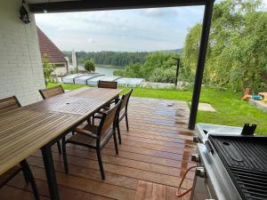 een terras met een tafel en stoelen en een grill bij Dům nad přehradou s bazénem in Lazinov