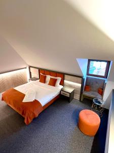 a bedroom with a large bed with an orange bedspread at Loft by Lumiere Sibiu in Sibiu