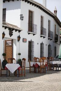 a group of tables and chairs in front of a building at Apartamentos La Ciudad in Ronda