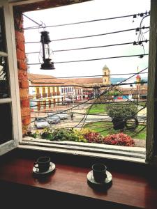 a window with two cups of coffee on a table at Donde Pepe Loft Apartasuite. in Zipaquirá