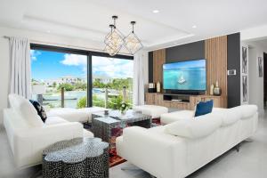 a living room with white furniture and a flat screen tv at Horizon Villa in Taylor Bay Beach