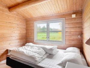 uma cama num quarto de madeira com uma janela em Holiday home Læsø II em Læsø
