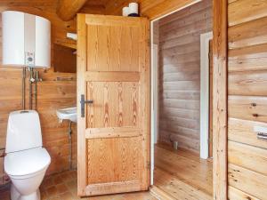 uma casa de banho em madeira com um WC e uma porta em Holiday home Læsø II em Læsø