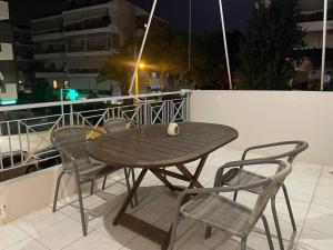 uma mesa de madeira e cadeiras numa varanda em DM Apartment 1 em Atenas