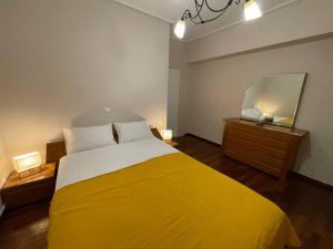 Un dormitorio con una gran cama amarilla y un espejo en DM Apartment 1, en Atenas