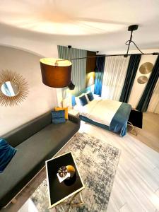 - une chambre avec un lit, un canapé et un miroir dans l'établissement Lumiere House Sibiu, à Sibiu