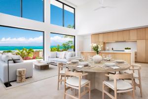 a dining room and living room with a table and chairs at Beachwood Villa in Turtle Cove