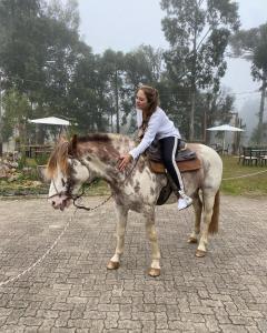 a young girl riding on a horse at WoodStone Hotel Fazenda in Gramado