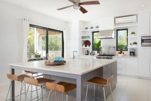 a kitchen with a large white island with stools at 18 Kelly Isle in Long Bay Hills