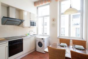 een keuken met een wasmachine en een tafel met stoelen bij Gemütliches Apartment in stylischer Stadtvilla in Goch