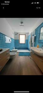 baño con 2 lavabos, bañera y 2 aseos en Casa Dani, en Baselga di Pinè