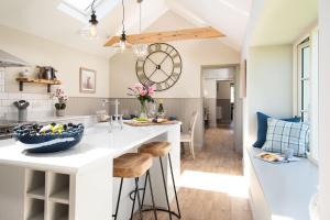 a kitchen with a large clock on the wall at Overview Cottage in Belford