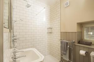 a white bathroom with a sink and a shower at Overview Cottage in Belford +12 photos