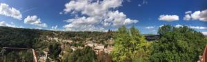 a town on a hill with trees and clouds at Joli Cocon pour 3 personnes vue sur les toits du centre de Caylus in Caylus