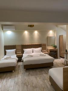 a hotel room with two beds and a mirror at SUNIBELROOMS in Paralia Katerinis
