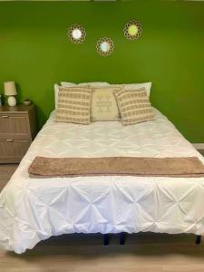 a bedroom with a white bed with a green wall at Midtown at Marion Green 1BR 1BA, 2 miles FAMU FSU, 2blks TMH in Tallahassee