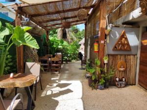 um restaurante ao ar livre com mesas, cadeiras e plantas em Hakuna Matata Glamping em Bacalar