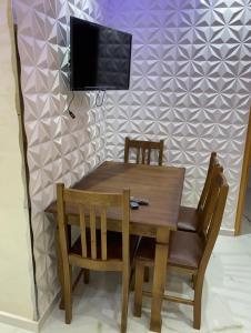 uma mesa de jantar e cadeiras com uma televisão na parede em Casa Yakhlef em Chefchaouen