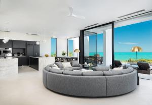 a living room with a large couch and a kitchen at UXUE Villa in Long Bay Hills