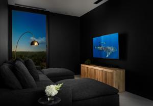 uma sala de estar com um sofá e uma televisão de ecrã plano em UXUE Villa em Long Bay Hills