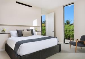 um quarto com uma cama grande e uma janela em UXUE Villa em Long Bay Hills