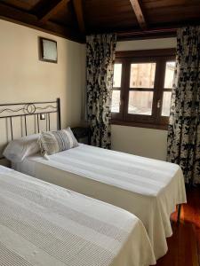 1 dormitorio con 2 camas y ventana en Las Teresitas, en Toledo
