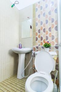 uma casa de banho com um WC branco e um lavatório. em Sea view 3 bedroom apartment em Mombasa