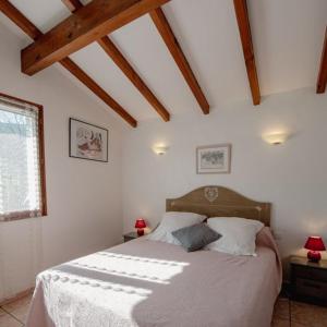 Un dormitorio con una cama con sábanas blancas y una ventana. en Goiz-izarra, en Saint-Martin-dʼArrossa