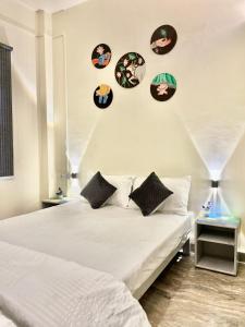 a bedroom with a white bed and some plates on the wall at Holy River Stays in Varanasi