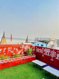 deux bancs assis sur le côté d'un bâtiment dans l'établissement Holy River Stays, à Varanasi