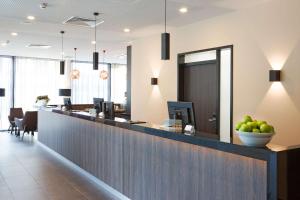 a lobby with a counter with a bowl of apples on it at GHOTEL hotel & living Essen in Essen