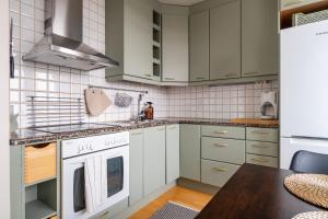 uma cozinha com armários brancos e um fogão em Kodikas asunto Tikkurilassa em Vantaa