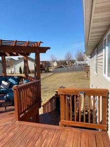 a wooden deck with a bench and a pergola at Beautifully Furnished 5-Bedroom in Rochester